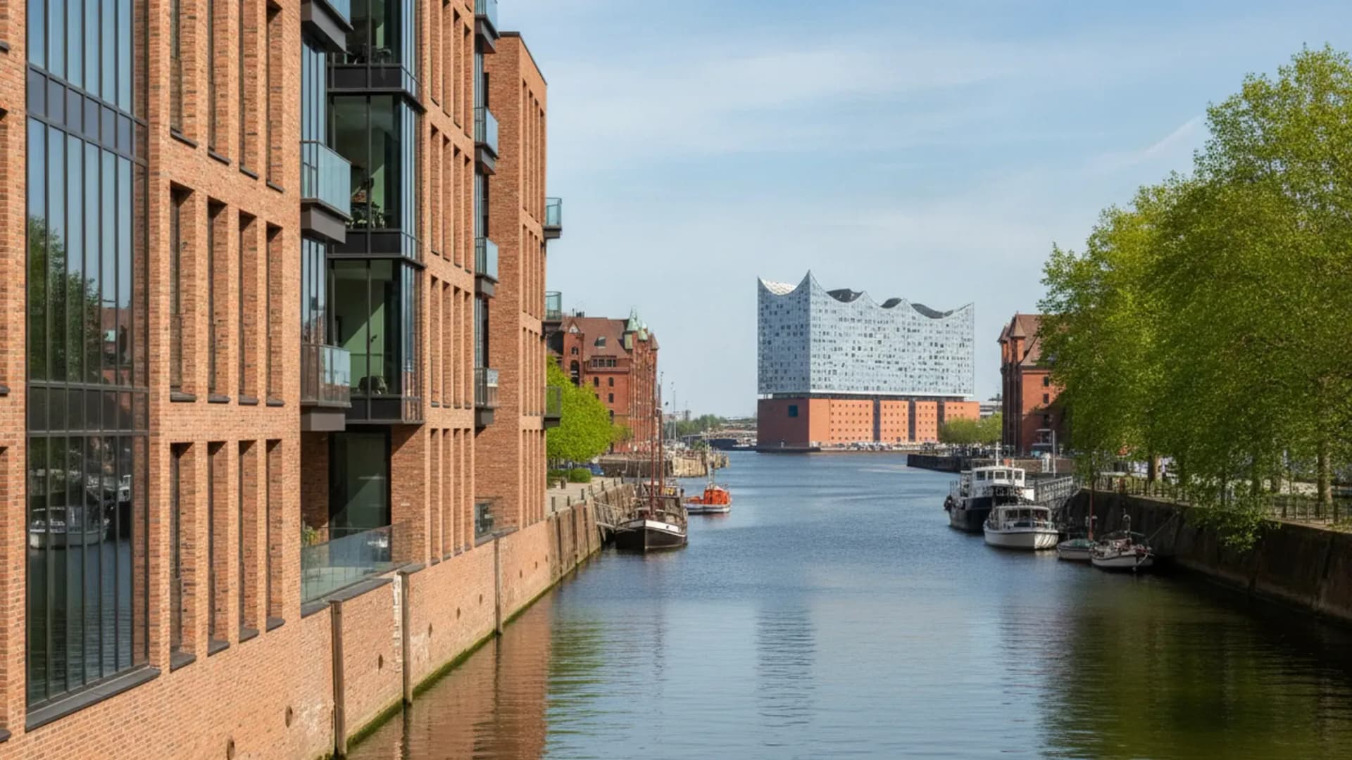 Backstein- und Glasarchitektur an einem Hafenbecken der Hamburger HafenCity mit Elbphilharmonie in der Distanz, KI-generiert