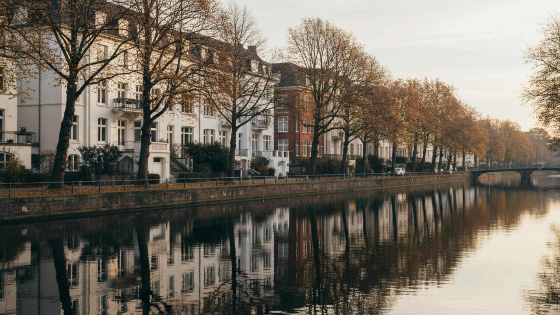 Weiße Stadtvillen an einem ruhigen Alster-Kanal in Hamburg-Uhlenhorst mit Spiegelung im Wasser